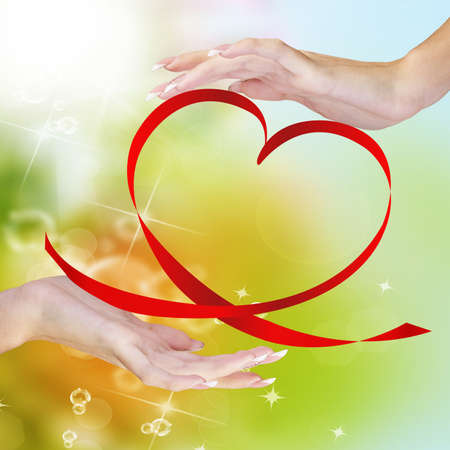 Valentine Heart  Elegant Red satin gift Ribbon in beautiful Woman handsの写真素材