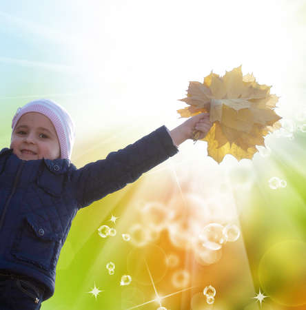 Happy Little Girl with bouquet autumn yellow dry leaves.Golden Autumn conceptの写真素材