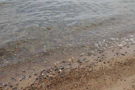 Stone beach on the North Sea. The coast along the ocean is sandy. The area is rocky green. The sky...