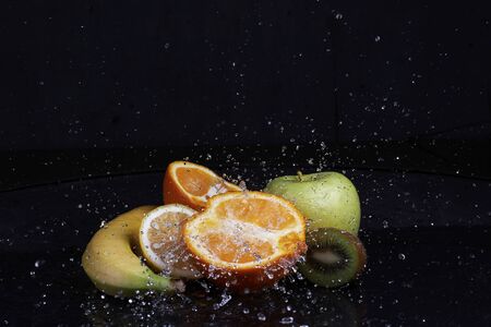 Fruits with water splash on black backgroundの写真素材