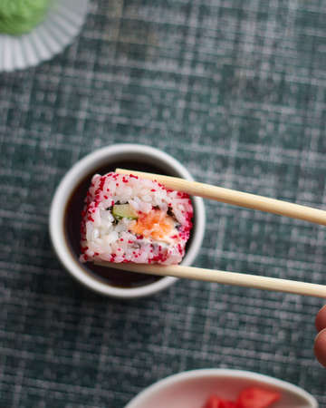 Sushi rolls. Japanese food in the restaurant. Sushi roll with salmon, vegetables, flying fish roe close-upの写真素材