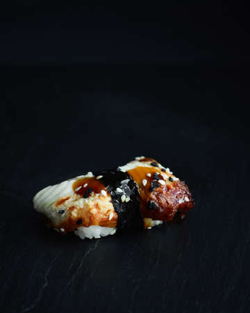 Sushi rolls. Japanese food in the restaurant. Sushi roll with eel on a dark backgroundの写真素材