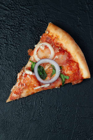 Tasty appetizing vegetarian pizza on dark stone background, top view