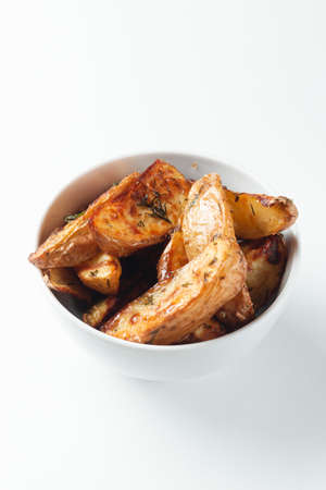 Bowl with tasty potato wedges on white isolated backgroundの写真素材