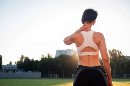 Fitness girl  doing stretching workout. Fashion sporty woman with strong muscular body training. Fit female stretching at outdoor stadiumの写真素材