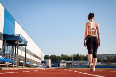 Woman getting ready to start on Stadium, summer outdoors training. Woman run training outdoors....