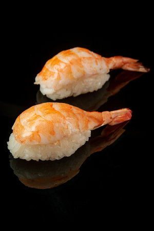 shrimp sushi on a black background with a reflectionの写真素材