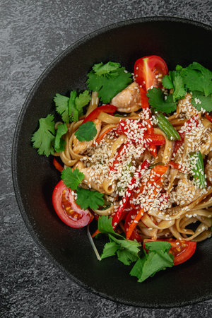 Wheat flour udon noodles with parsley, tomatoes and sprinkled with sesame seedsの写真素材