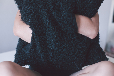 black pillow in hands of a blonde girlの写真素材