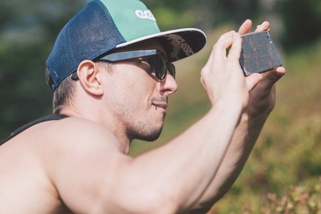boy taking photos on his smartphone outsideの写真素材