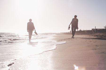 girl and boy at the seashore in sunsetの写真素材