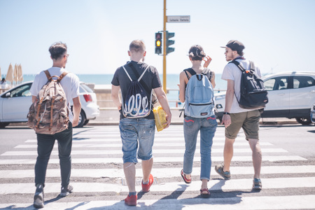 friends are crossing road to the seaの写真素材