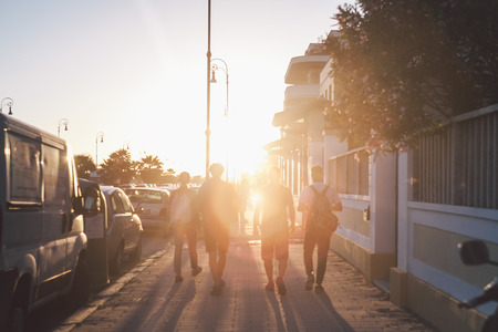 friends walking through the street in sunsetの写真素材