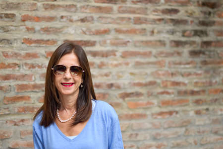 woman looking to camera with sunglasses smilingの写真素材