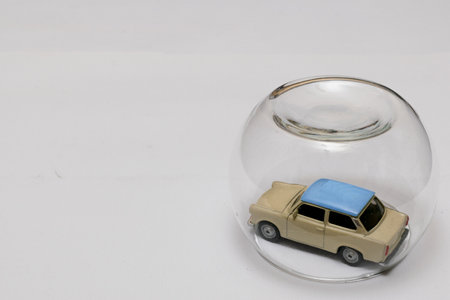 Toy car protected by translucent glass bubble on the left side with free space on the right to writeの写真素材