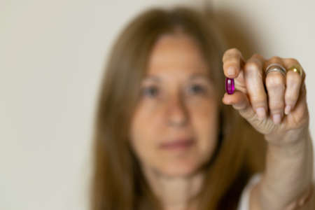 Woman holding medicine capsule or tablet with her handの写真素材