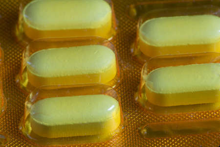Drug tablets in yellow color macro photographyの写真素材