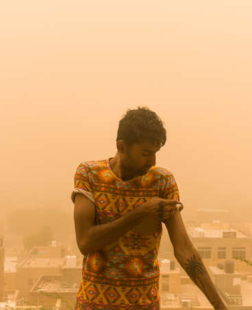 man showing off his physique outdoor during sandstormの写真素材