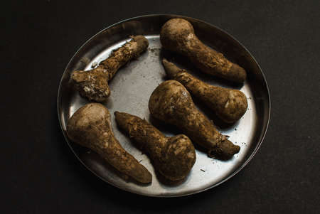 dirty plucked mushroom high in calcium placed in a plate on a black textured background conceptの写真素材