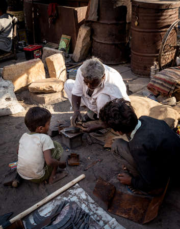 Rajasthan, India, India - CIRCA 2021: children learns blacksmith from their grandfatherのeditorial素材