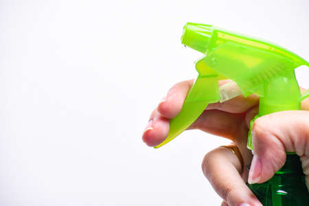Hand holding plastic spray bottle - hold plastic spray bottle isolated on white. Man with water sprayer in hand.の写真素材