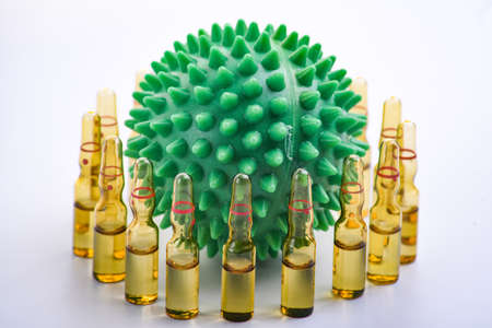 Copy space transparent medical ampoules in a row. Children's colored toys in the form of viruses....