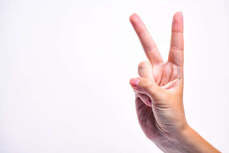 The girl's hand show a victory hand. Symbol of victory. Hand isolated on white background. Copy...
