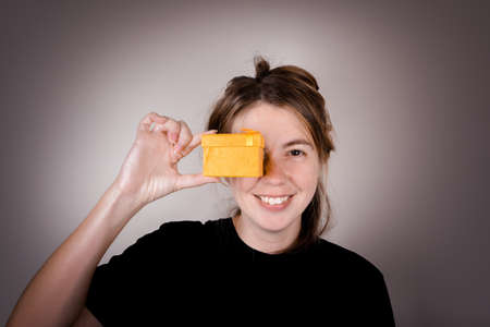 young woman in a black t-shirt on a white background is happy to accepting gift. accept gifts...
