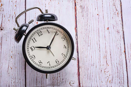 close-up black alarm clock on a white wooden background. Lost time concept. Business idea. Lifestyleの写真素材