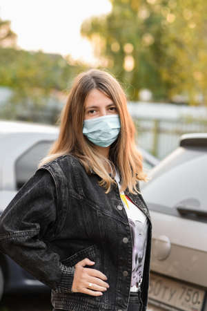 woman wears a medical mask because air pollution or virus is an epidemic in the city. Breathing protection concept. Woman in medical mask looking at the cameraの写真素材