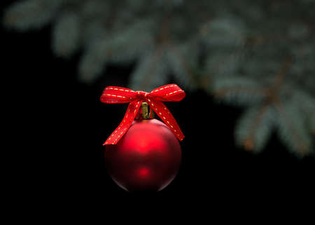 Red christmas ball on black background