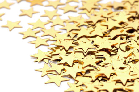 Christmas decoration of golden confetti stars against white 
