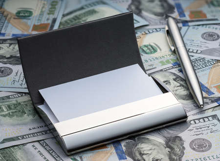 Business card holder and pen on the background of the new hundred dollars Americanの写真素材