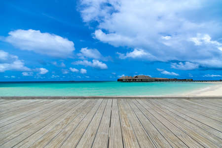 Wooden gray pier on perfect beach in sunny day with blue sky