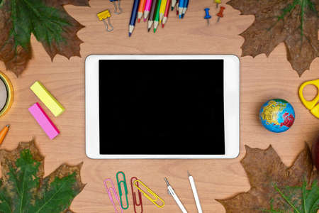 Back to School concept . School supplies and tablet on wooden school desk from aboveの写真素材
