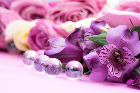beautiful flowers and glass ball on pink backgroundの写真素材