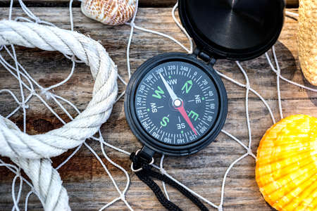 Wooden background with starfish, compass and shell - maritime decoration.