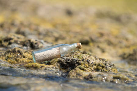 Message in a bottle washed ashore on a tropical beach.