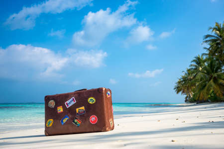 Travel  vintage suitcase is alone on a beachの写真素材