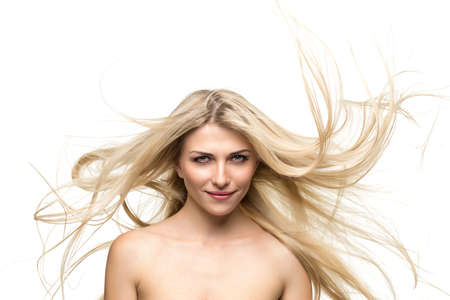 portrait of a beautiful blonde woman with hair fluttering in the wind isolatedの写真素材