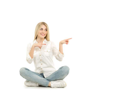 Woman sitting on the floor and pointing with her fingerの写真素材