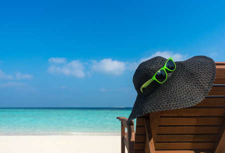 Beach chairs with hat on white sandy beach