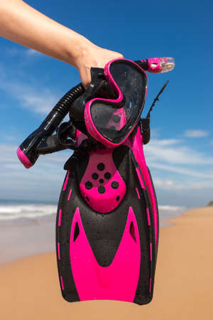 Woman holding mask and flippers for swimming on the background the azure seaの写真素材