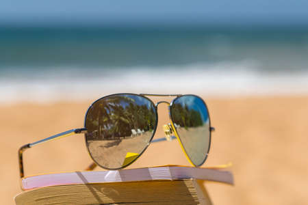 Books and sunglasses on a beachの写真素材