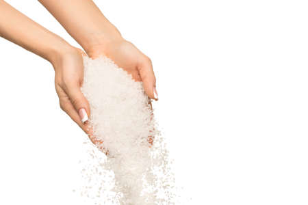 Sea salt crystals in women hand on white background
