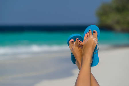 Close-up of female foot in the blue water on the tropical beach. Vacation holidays.の写真素材