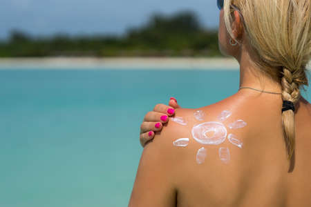 Woman with sun-shaped sun creamの写真素材