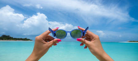 Picture of sunglasses on the tropical beach, vacation. Traveller dreams concept, panorama formatの写真素材