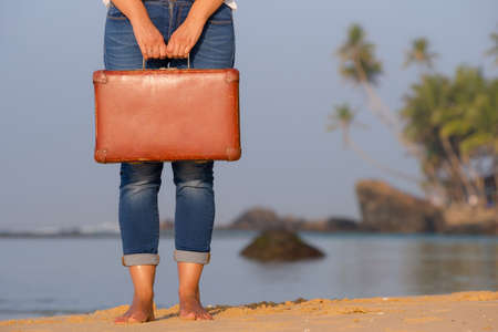 Beautiful girl with a old vintage suitcase in a beachの写真素材