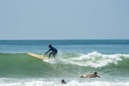 WELIGAMA, SRI LANKA - JANUARY 09 2017: Unidentified man surfing on a large wave on Weligama beach on the coast of Indian ocean  - is the best surf paradise in Sri Lankaのeditorial素材